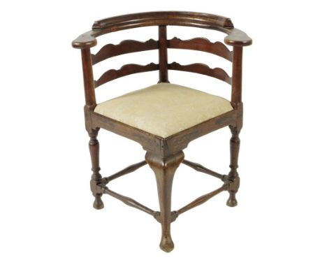 A George II oak corner armchair, the shaped ladder back above a drop-in seat, with baluster turned supports, united by stretc