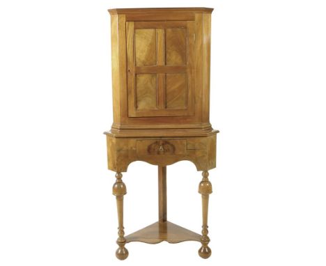 A walnut standing corner cupboard on stand in early 18th century style by Elsie Robinson, the panelled door enclosing two she