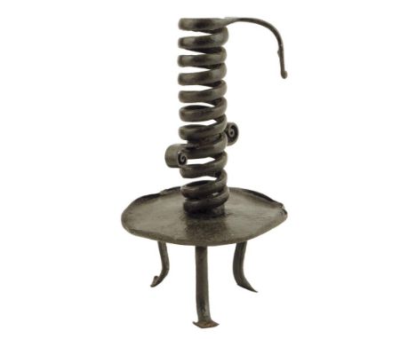 An 18th century wrought iron spiral or 'coil' candlestick, with an adjustable disc above a drip-tray and tripod supports, 20.