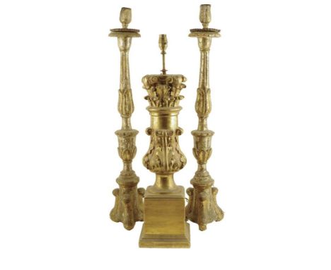 A pair of 18th century Italian silvered wood altar candlesticks, each with a fluted lappet carved stem and triform base, 82.2
