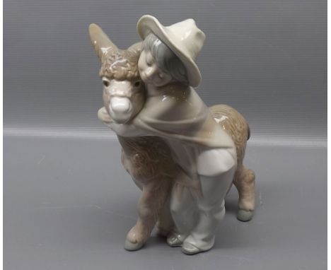 Lladro model of a young boy cuddling a donkey, 8 1/2 ins tall  