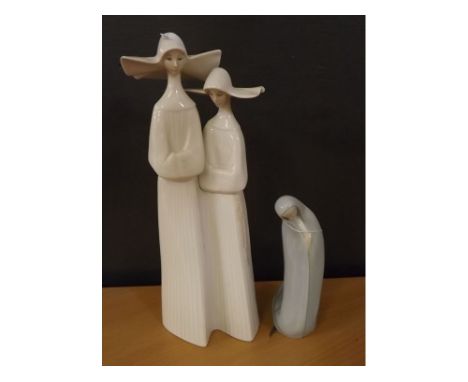 Lladro figure of a kneeling cloaked woman, together with a further Lladro figure of two nuns, largest 13 ins  