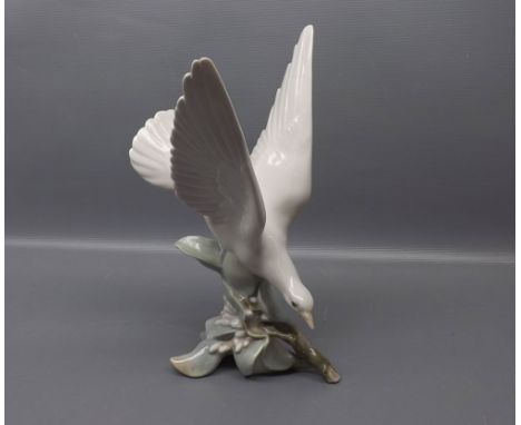 Lladro model of a seagull, with wings raised, standing on a branch, 11 ins tall  