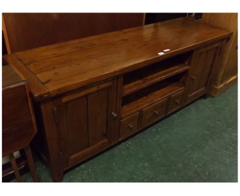 Modern pine framed television cupboard centrally fitted with open shelf, three small drawers flanked either side by panelled 