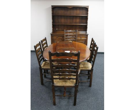 An oval oak farmhouse kitchen table and six ladder back chairs 