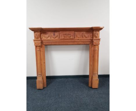A heavily carved pine fire surround  CONDITION REPORT: 124cm high by 140cm wide by 22cm deep. 