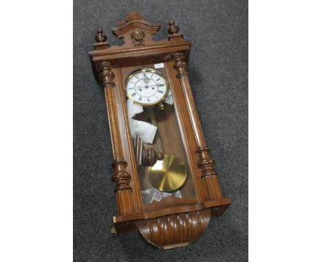 An antique mahogany cased wall clock with pendulum, weights and key