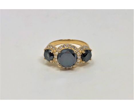 A 14ct gold black diamond trilogy ring, the black diamonds weighing 3.35 carats, further set with 0.41 carat of diamonds, siz