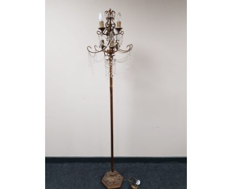 A decorative metal six way floor lamp with glass drops 