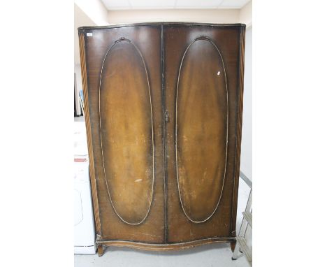 A walnut bow fronted double door wardrobe 