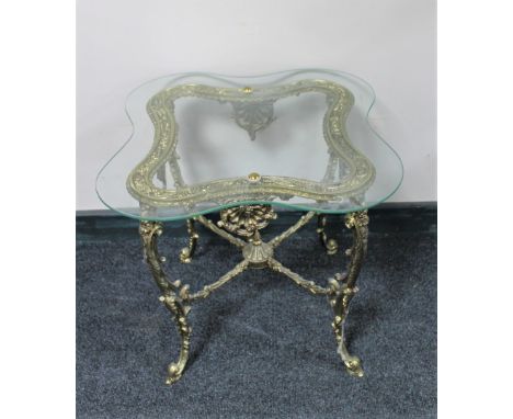 A shaped glass topped lamp table on ornate gilt metal base 