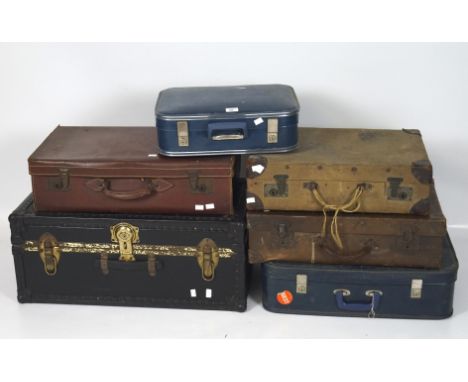 A travelling trunk and five vintage suitcases, the trunk in black with studded bindings, width 76cm, the suitcases in assorte