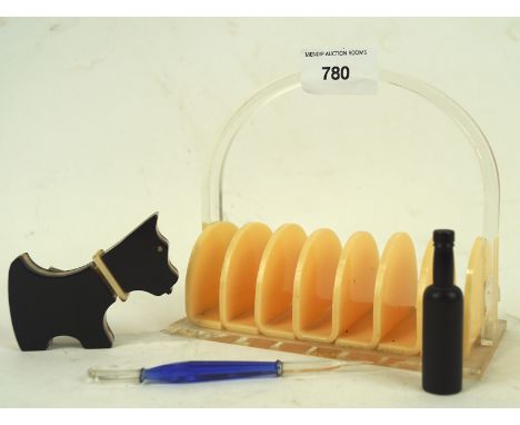 Four 20th century Bakelite items, including a toast rack, a novelty lighter modelled as a Scottie dog, a pencil modelled as a