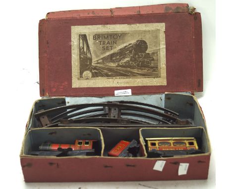 A Brimtoy tinplate O gauge train set, including a locomotive and tender with a dining car and lengths of track, in the origin