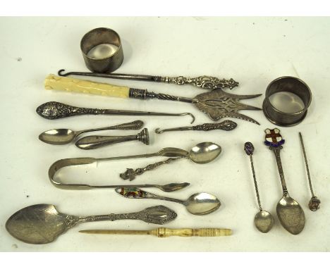 An assortment of silver and silver plate, including a pair of sugar tongs, two napkin rings, button hooks, a seal stamp, spoo