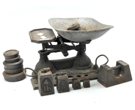An early set of cast iron kitchen scales with a quantity of related weights, 36cm wide