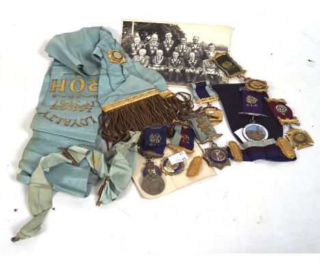 A collection of Masonic regalia, to include three hallmarked silver jewels, each with ribbons. Masonic sash and more