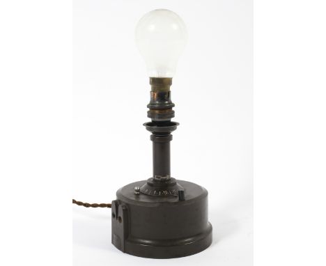 An early 20th century wind-up Bakelite table lamp, with central dial and on/off switch, with cylindrical Bakelite base, the u