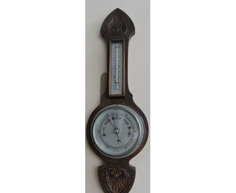 A 20th century barometer, with a carved frame incorporating a thermometer, H. 57cm.
