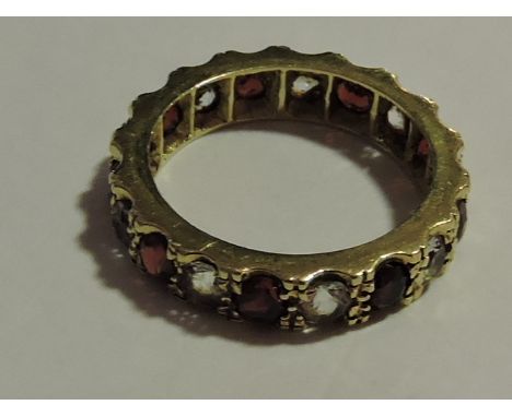 A diamond and ruby full hoop eternity ring, set in a yellow metal band stamped 9ct, 2.9g.