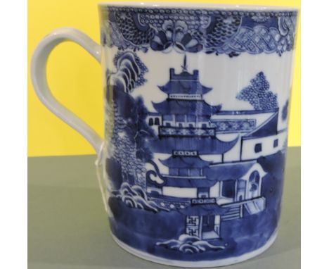 A late 18th century Chinese large blue and white tankard mug, decorated all round with a river village landscape scene, H: 14