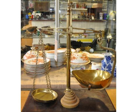 A set of late Victorian Avery brass balance scales on rectangular mahogany plinth with a set of weights. 
