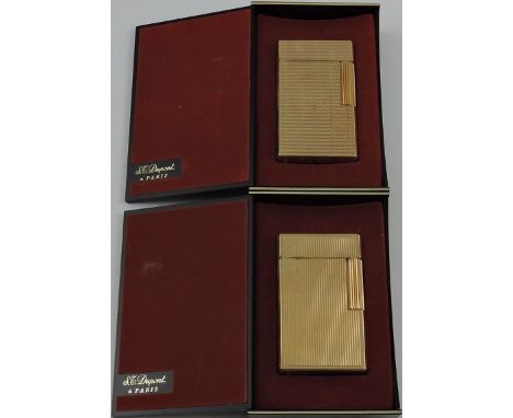 A Dupont gold-plated light, of ribbed decoration; in plastic retail box; together with another similar. (2)