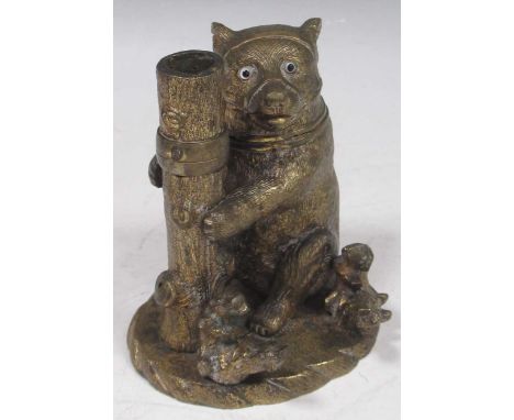 A late 19th century gilt bronze muzzled bear desk inkstand with a hinged head revealing inkwell, glass eyes, supporting a tre