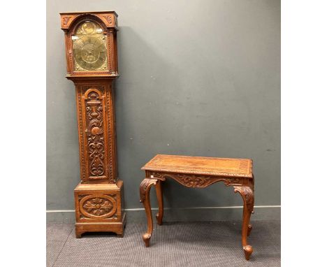 An oak carved longcase clock, decorated with a knight's helmet and swords, the fronton inscribed 'Cuth Darton / Durham' and d