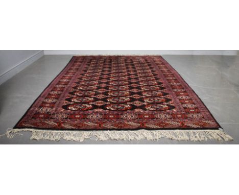 A Turkoman carpet, woven with three rows of twelve guls on a black ground, 235cm x 157cm Good overall condition