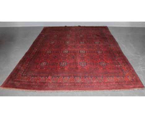 A Meshad carpet of Turkoman design, woven in muted colours on a red ground, 340cm x 255cm Good overall condition