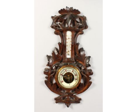 A CARVED WOOD THERMOMETER BAROMETER. 18ins long.