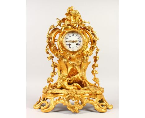 A 19TH CENTURY FRENCH ORMOLU MANTLE CLOCK, with eight-day movement, striking on a bell, with white enamel dial, the ornate ca