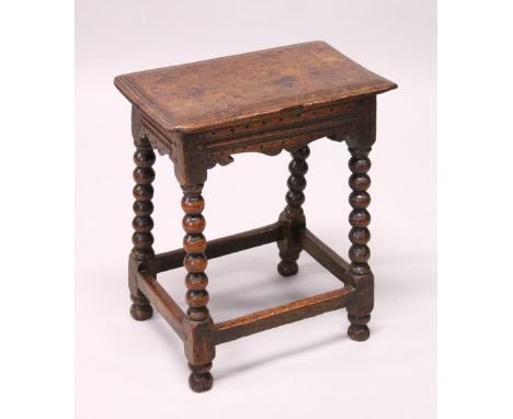 AN 18TH CENTURY OAK JOINT STOOL, with a moulded top, shaped frieze on bobbin turned legs united by stretchers. 46cms long x 2