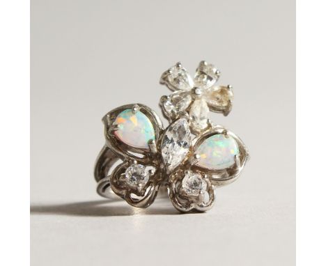 A SILVER GILSON OPAL AND CZ CROSSOVER RING.