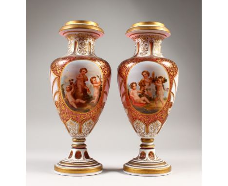 A GOOD LARGE PAIR OF BOHEMIAN RUBY GLASS VASES, with gilt and white enamel decoration, painted with a panel of cupids gatheri