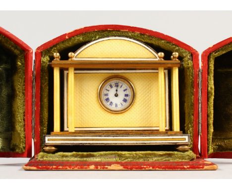 A GOOD SMALL SILVER GILT AND YELLOW ENAMEL TRAVELLING CLOCK, with dome top and columns to each side, in a fitted leather case