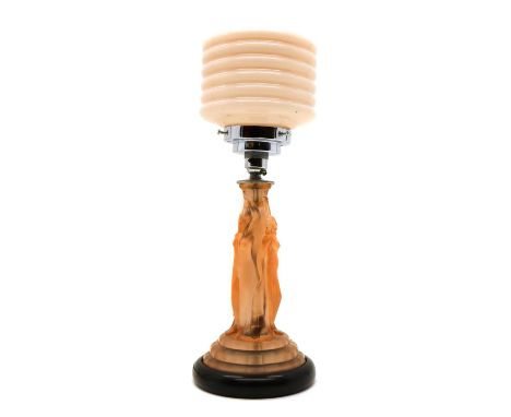 An Art Deco 'Three Graces' table lamp,the column moulded with three ladies, on an ebonised plinth, with a pink glass shade, 4