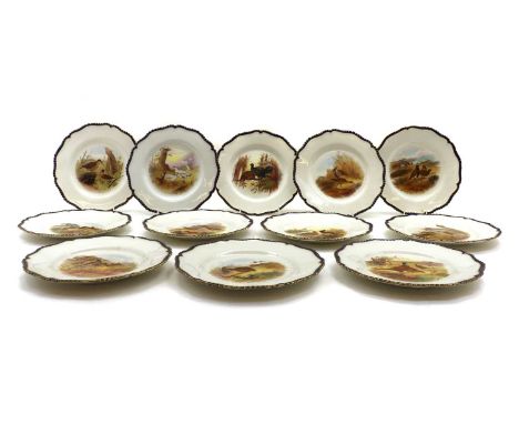 A set of twelve Royal Worcester porcelain dessert plates,decorated with different game birds, within blue and gilt borders, o
