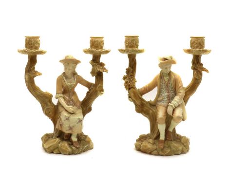 A pair of Royal Worcester blush ivory candelabrum,late 19th century, modelled as figures on a tree stump, printed marks,25cm 