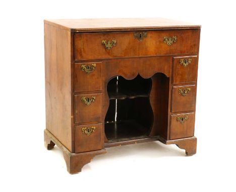 A walnut kneehole desk,18th century and later, with an arrangement of seven drawers, over an apron shelf,80cm wide50cm deep81