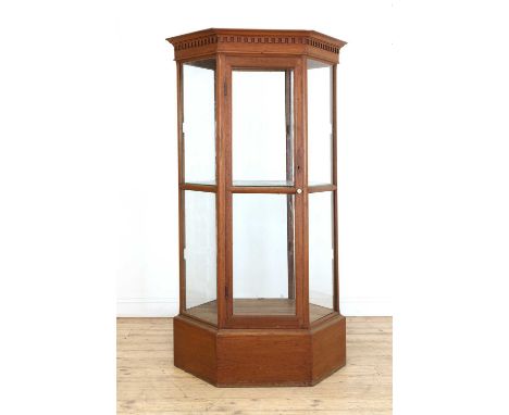 An oak museum vitrine, mid-20th century, of hexagonal form, the cornice moulded with a crenulated frieze, with internal glass