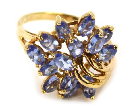 A 9ct gold QVC dress ring, with elaborate left scroll flower spray, set with pale blue/purple tanzanite stones, ring size R½,