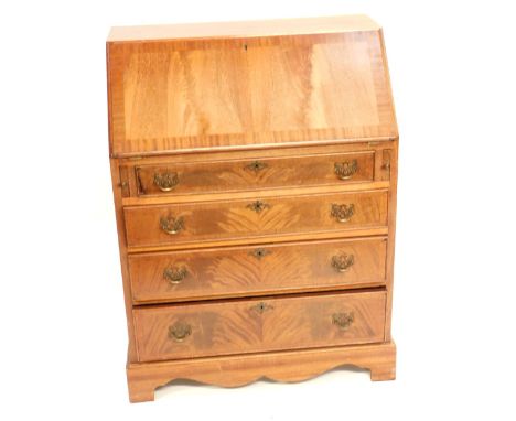 A flame mahogany and cross banded bureau, the fall flap opening to reveal two drawers and six recesses, over four long gradua