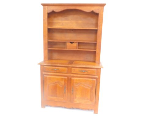 A 20thC oak dresser, the out swept pediment over three shelves, with a drawer to the lower shelf, above two drawers and a pai
