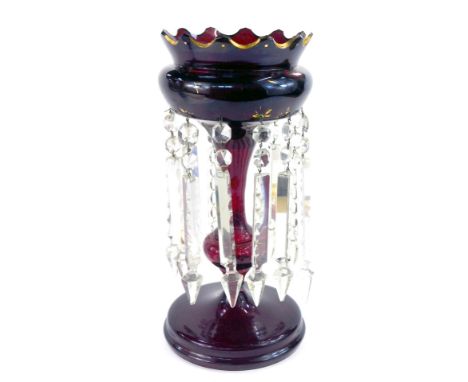 A late 19thC ruby glass lustre, with fluted glass top, with gilt highlights, on a stepped foot, with clear prismatic drops, 4