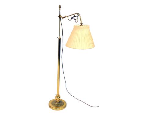 A late Victorian brass gasolia standard lamp, converted to electricity, the branch with foliate scrolling, terminating in a p