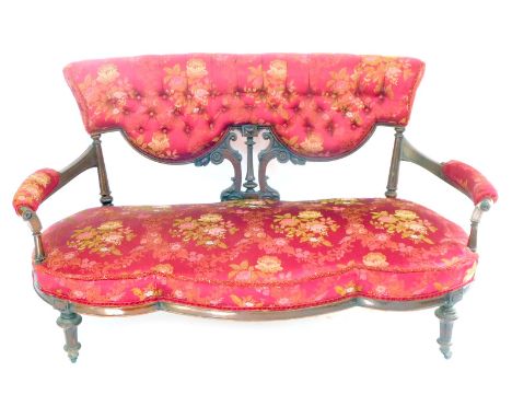 A Victorian walnut serpentine show frame two seater sofa, upholstered in button back red and floral decorated fabric, overstu