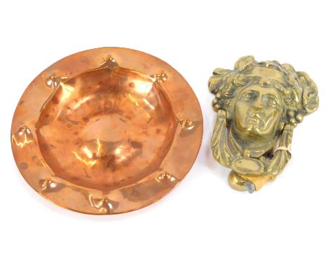 An Arts and Crafts hammered copper bowl, 21cm wide, and a brass Dionysus door knocker, 17cm high. (2)