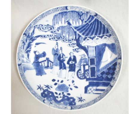 A Kangxi dish, painted with five figures outside a pavillion below a willow and clouds, 25cm diameter  